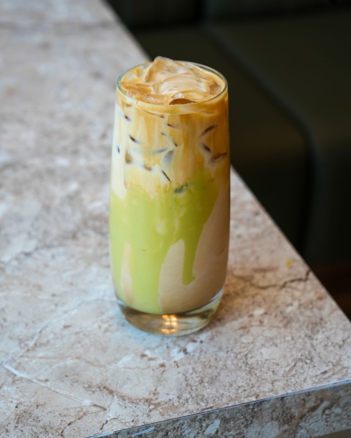 An iced pistachio latte on the marble counter